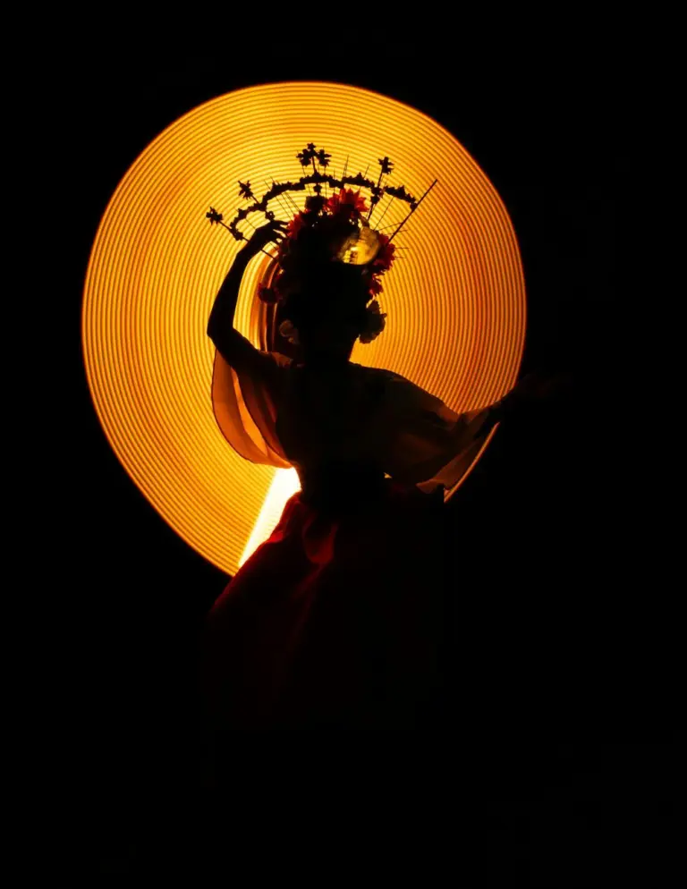 Silhouette of a traditional Catrina figure against a warm, glowing background in Ciudad de México.