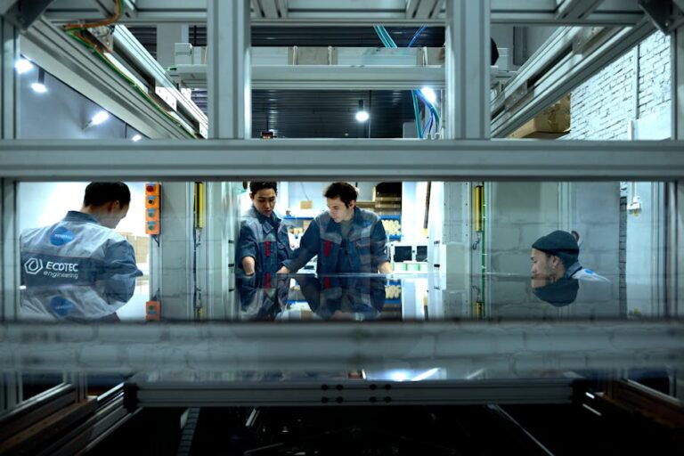 Engineers collaborate over advanced machinery in a high-tech indoor workspace.