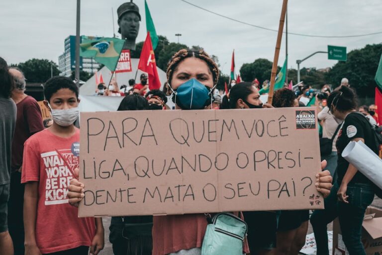 Large gathering in Rio de Janeiro, Brazil, featuring protestors holding signs against government policies.